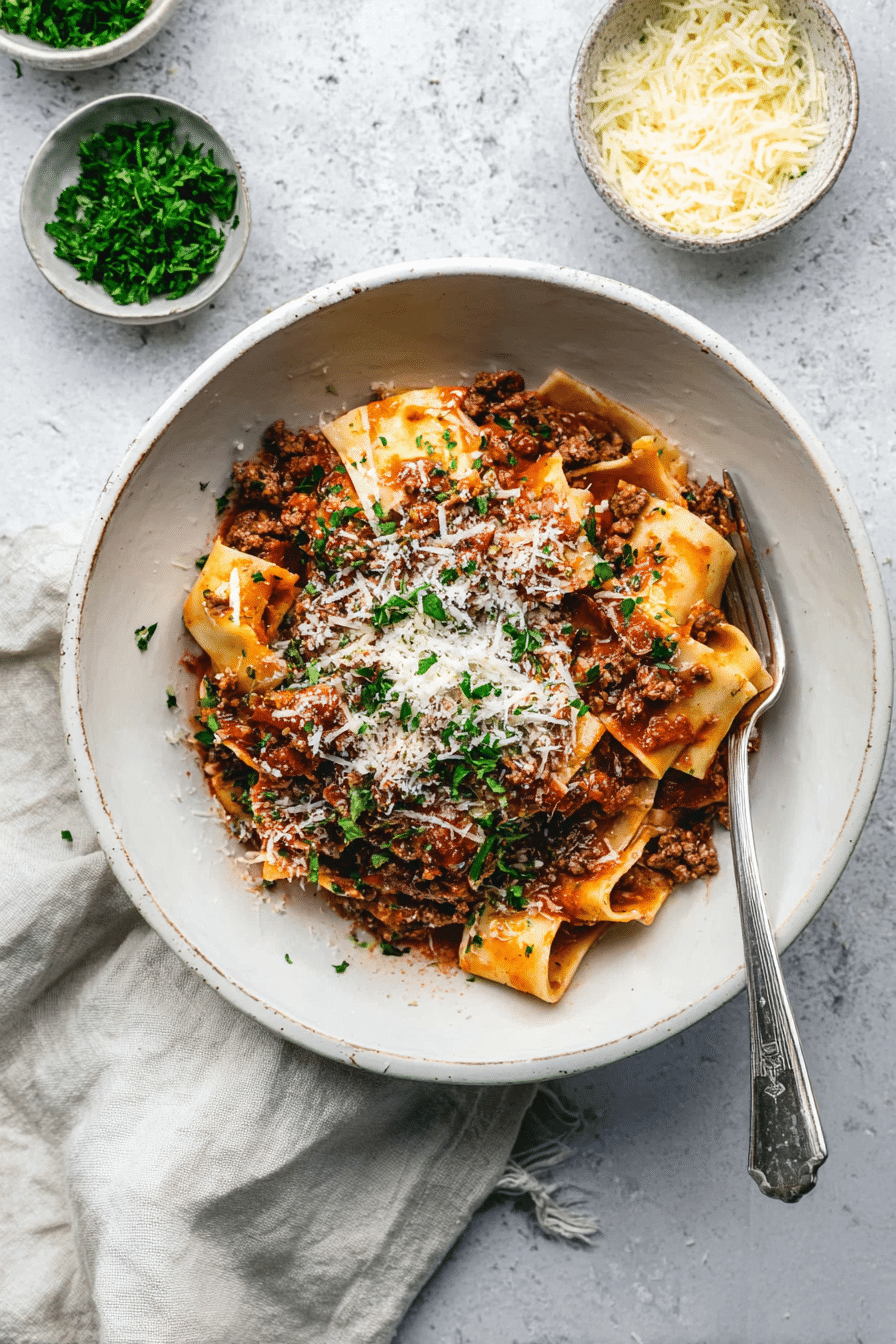 Easy Lamb Mince Ragu with Parmesan and Fresh Herbs Easy Lamb Mince Ragu topped with Parmesan and herbs in a white bowl