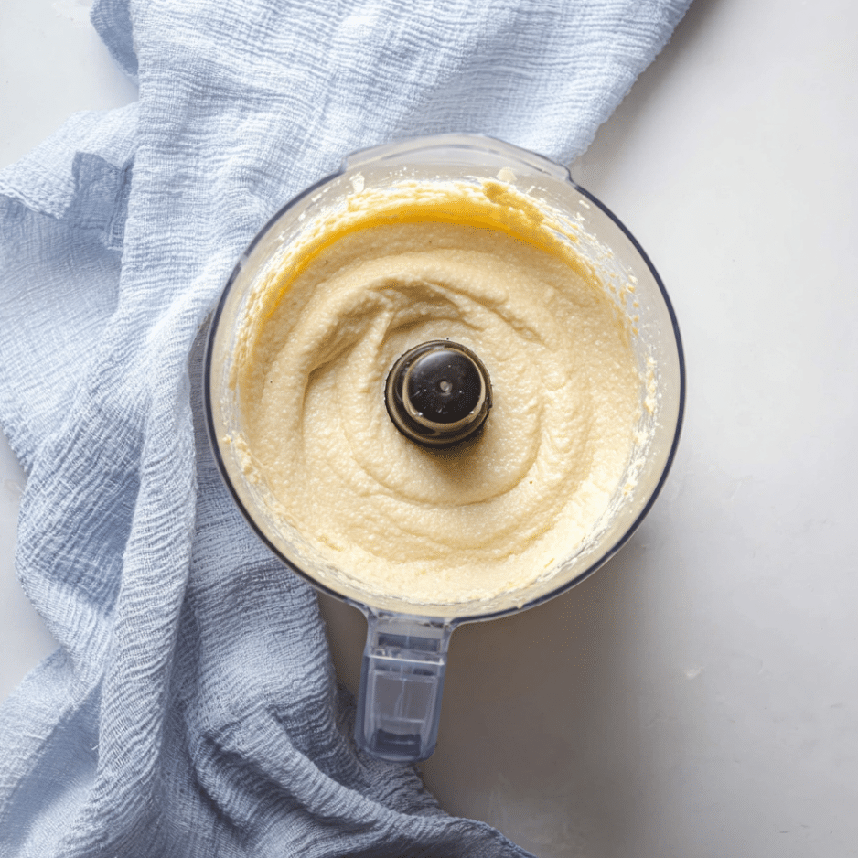Blended Keto Cupcake Batter Smooth keto cupcake batter fully blended in a food processor with blue towel