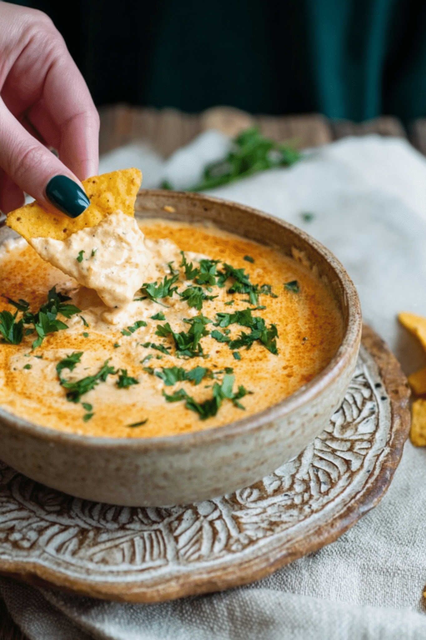 Serving Creamy Cottage Cheese Queso Hand dipping tortilla chip into cottage cheese queso