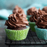 Keto chocolate cupcakes with piped ganache in green liners