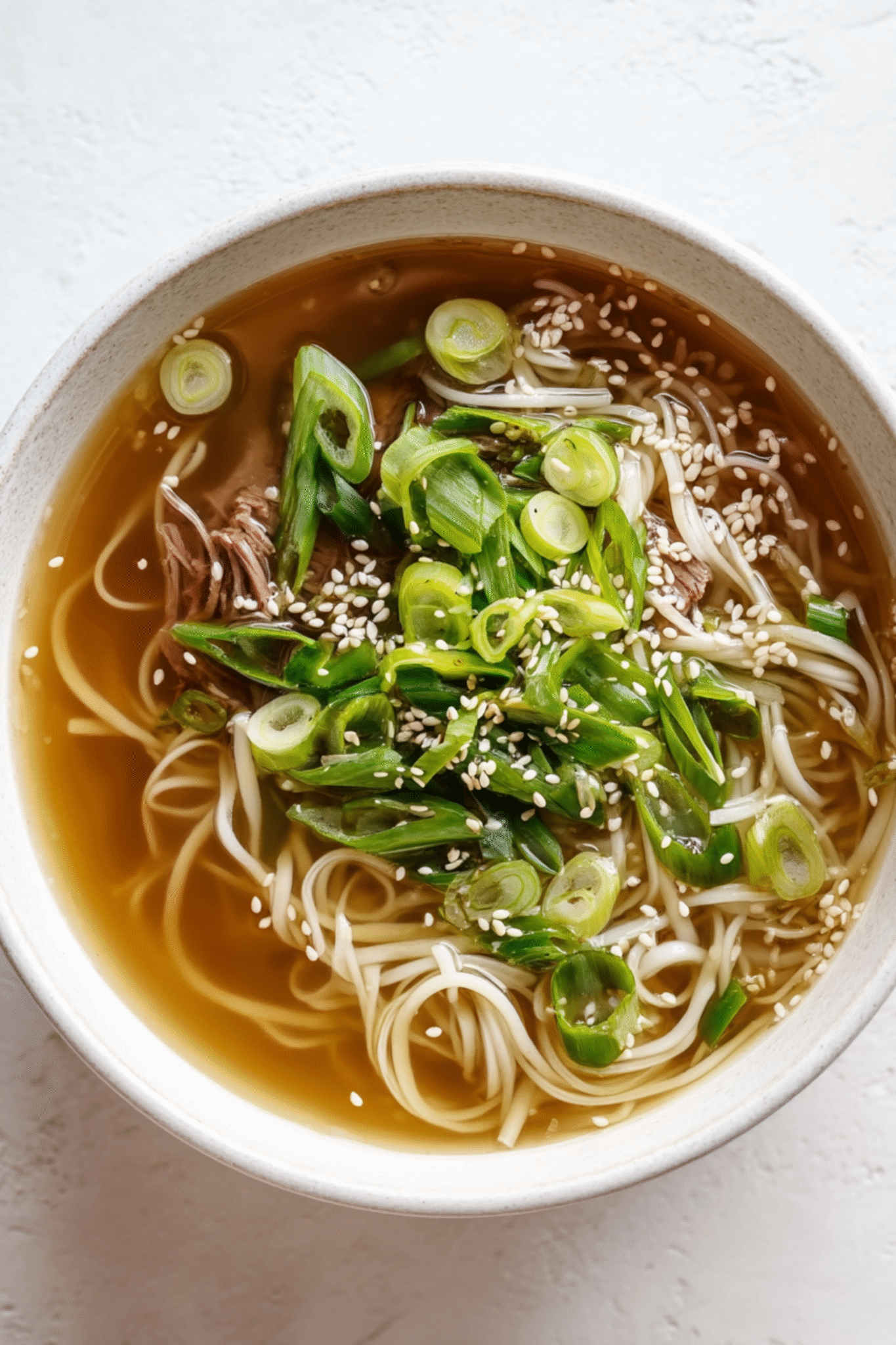 Serving Homemade Beef Bone Broth with Fresh Garnishes Serving Homemade Beef Bone Broth with noodles and scallions