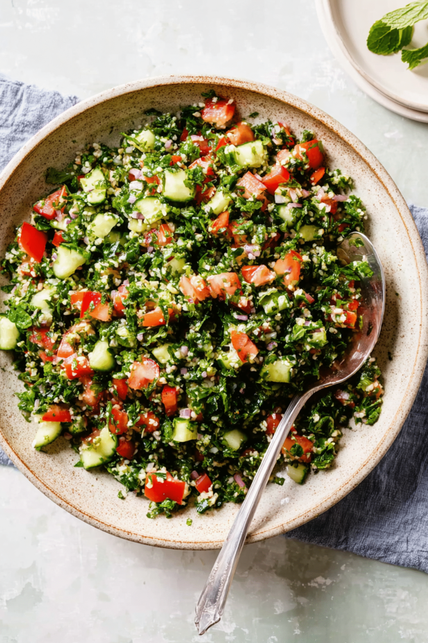 Serving Tabbouleh Salad – Ready to Enjoy Served bowl of tabbouleh salad with spoon and mint garnish